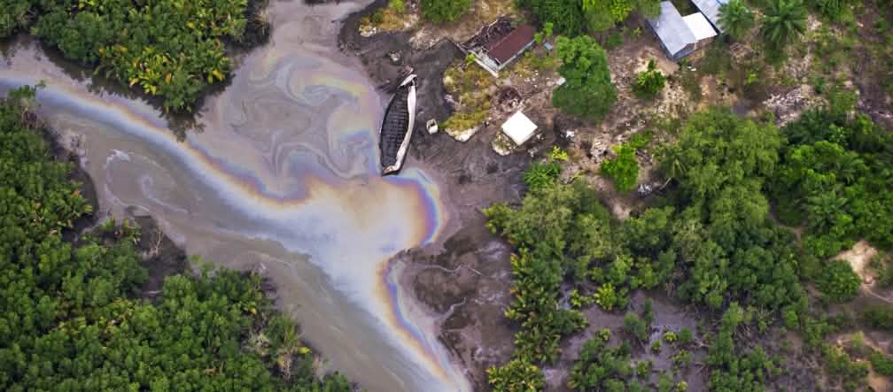 Een film van olie vervuilt een rivier in de Nigerdelta Luchtfoto van oil spill in Nigeria