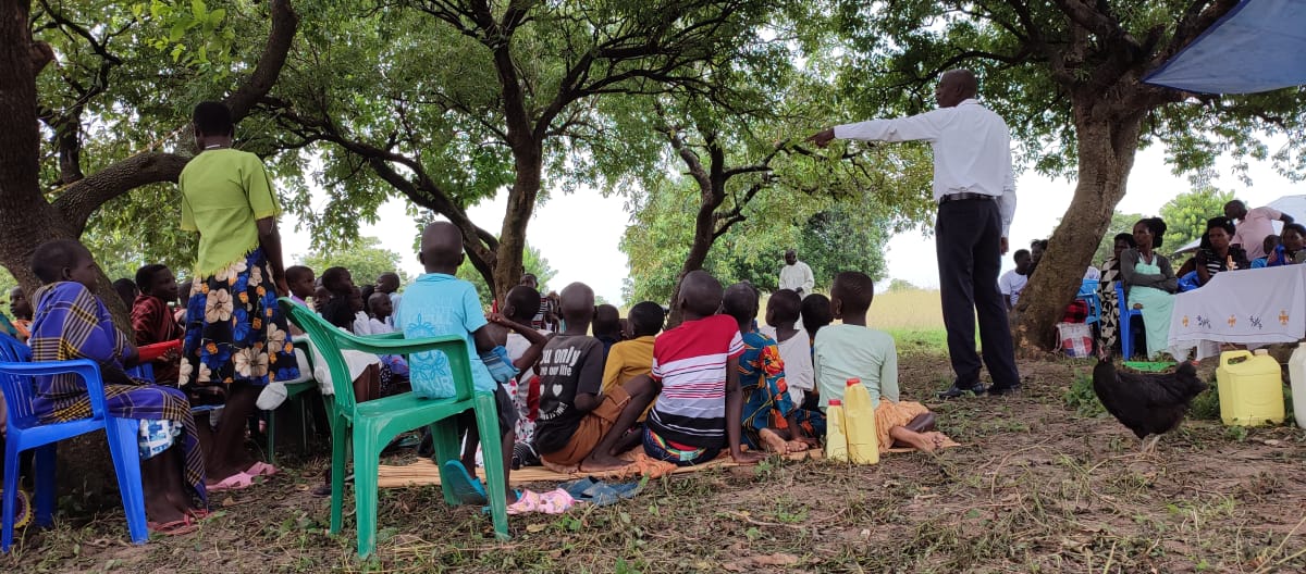 Een medewerker van TASHA informeert in een dorp over de gevaren van aardolie-winning